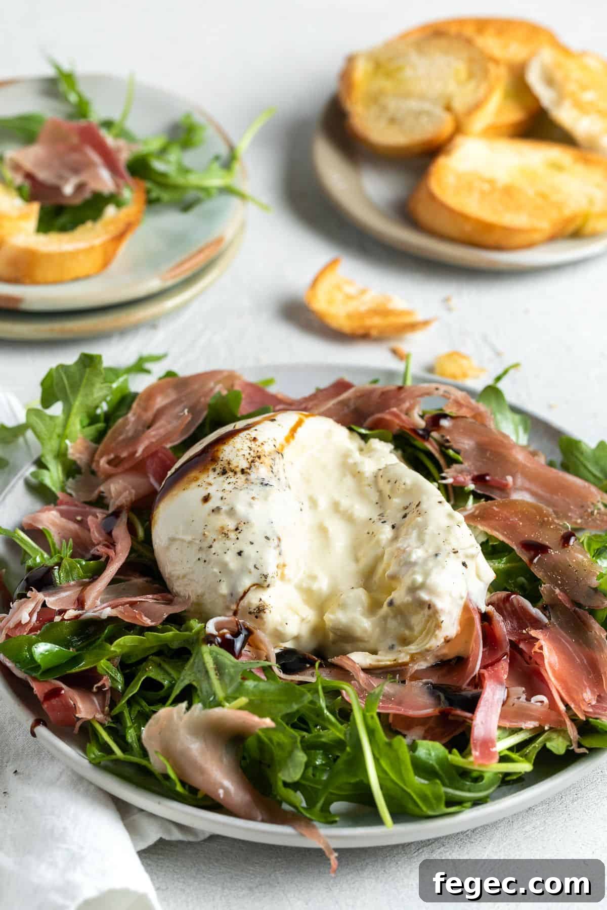 The burrata appetiser having been cut into to show the creamy centre of the cheese.