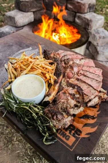 The grilled ribeye with beef tallow fries on a cutting board.