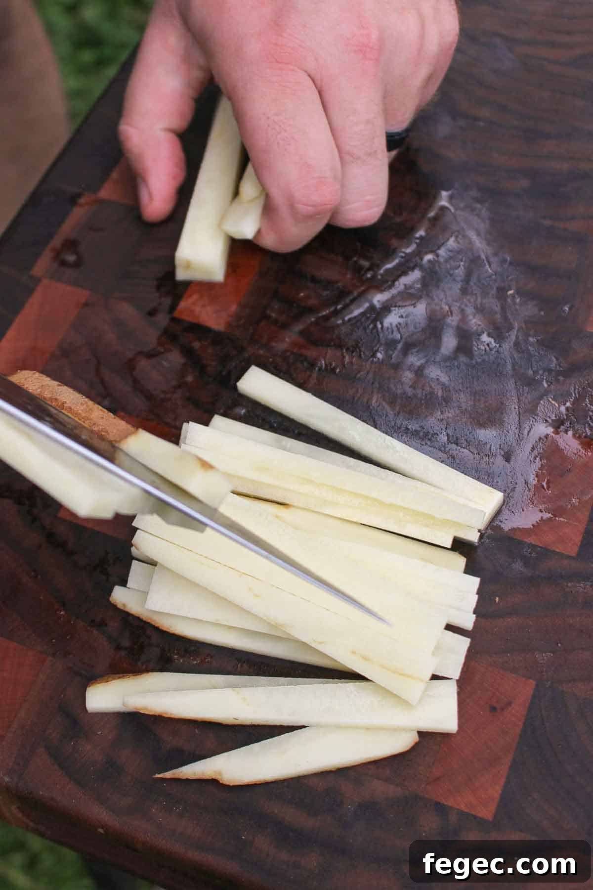 Slicing up the russet potato into slices for our Garlic Butter Chili fries.