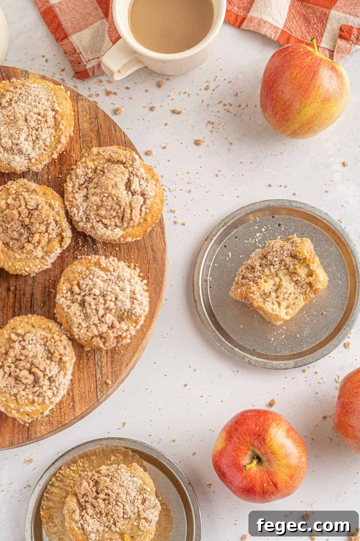 A counter full of spiced apple muffins and one cut in half.