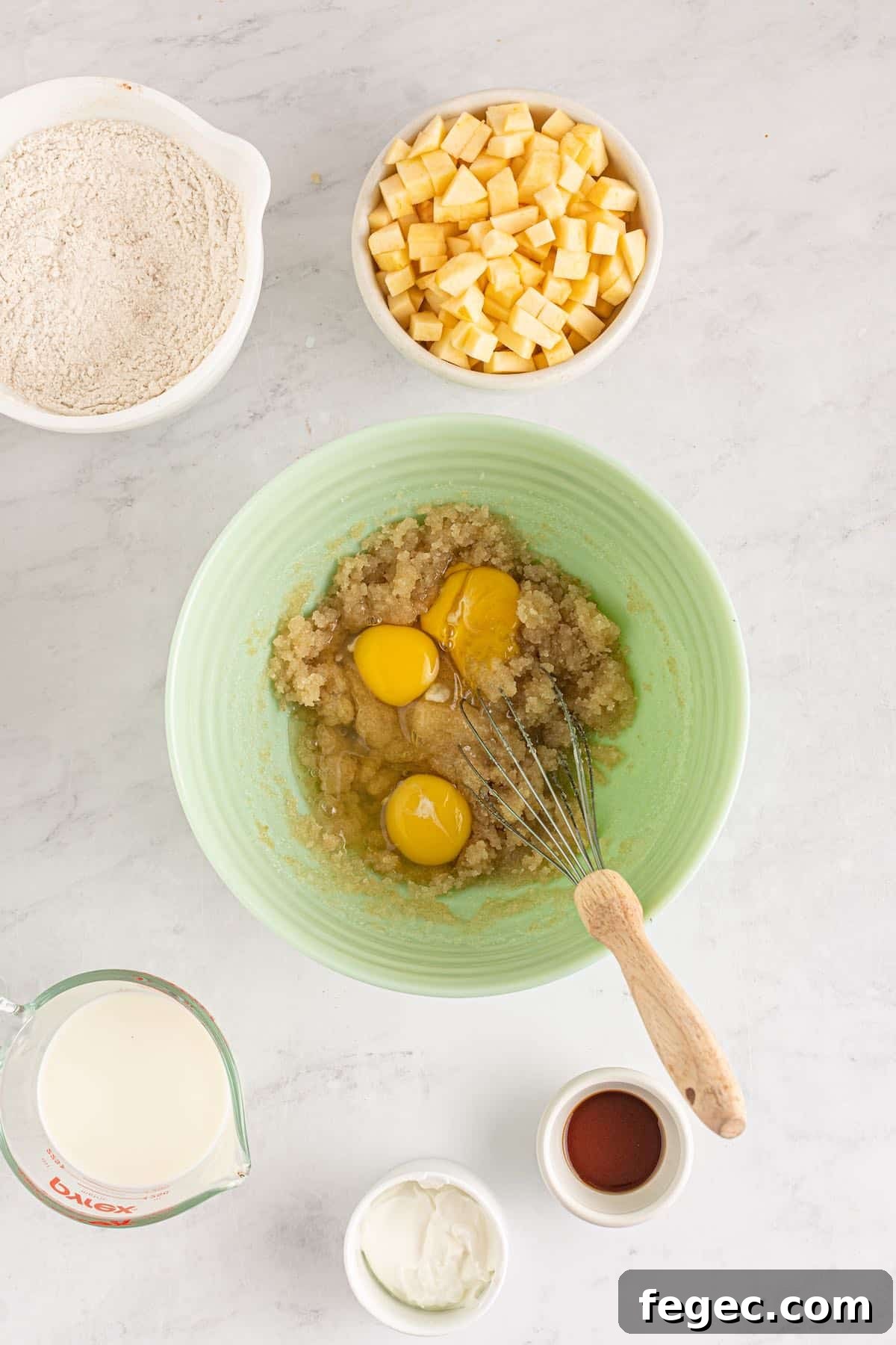 Eggs in a batter bowl with a whisk.