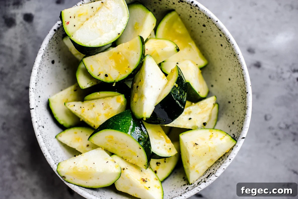 Chopped zucchini in a bowl with lemon zest.