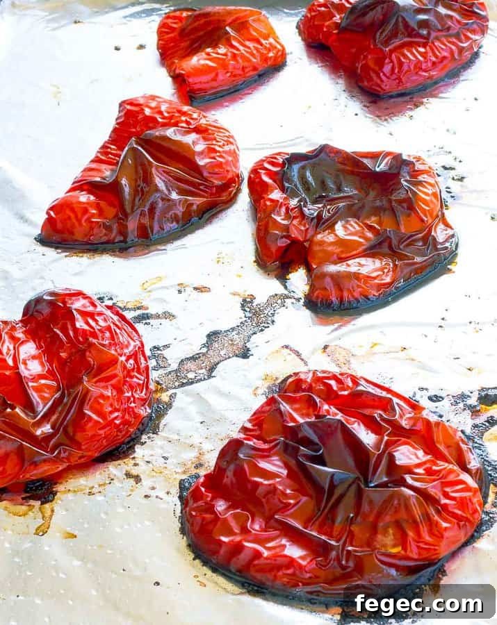 Six roasted red pepper halves on a foil lined cookie sheet