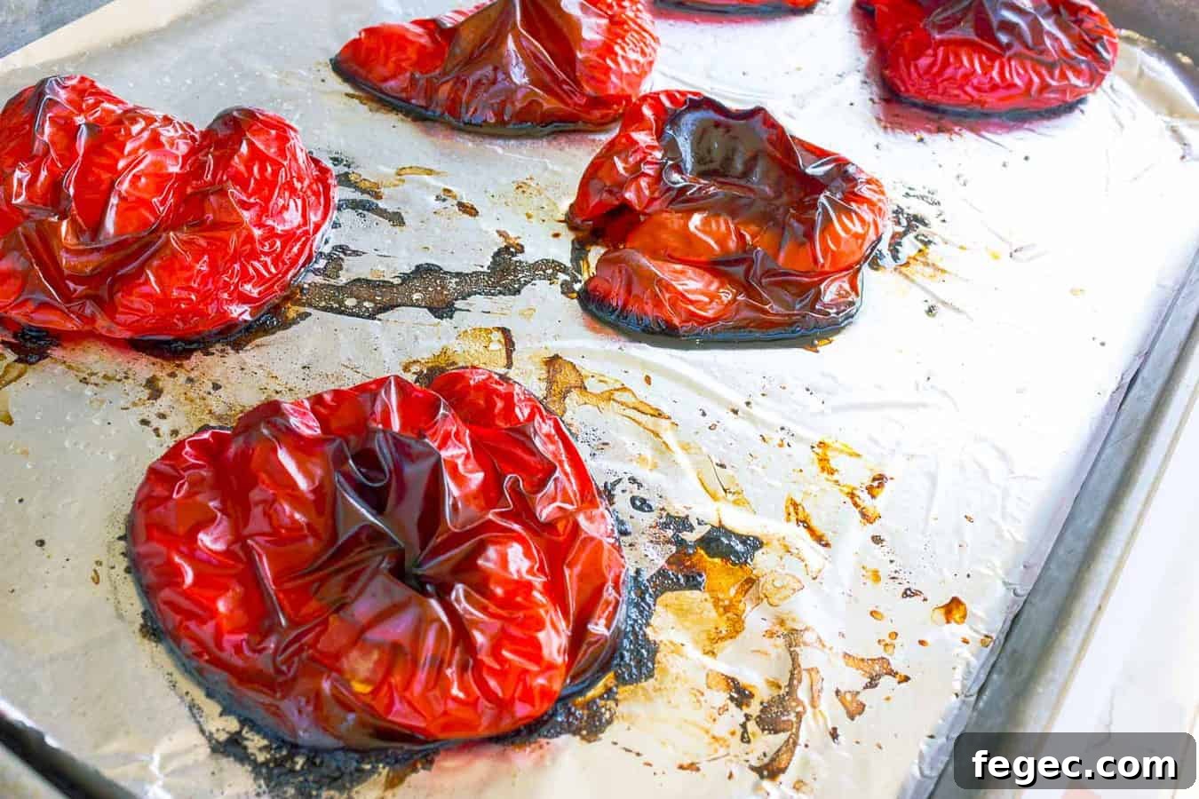 Roasted red peppers cut side down on cookie sheet