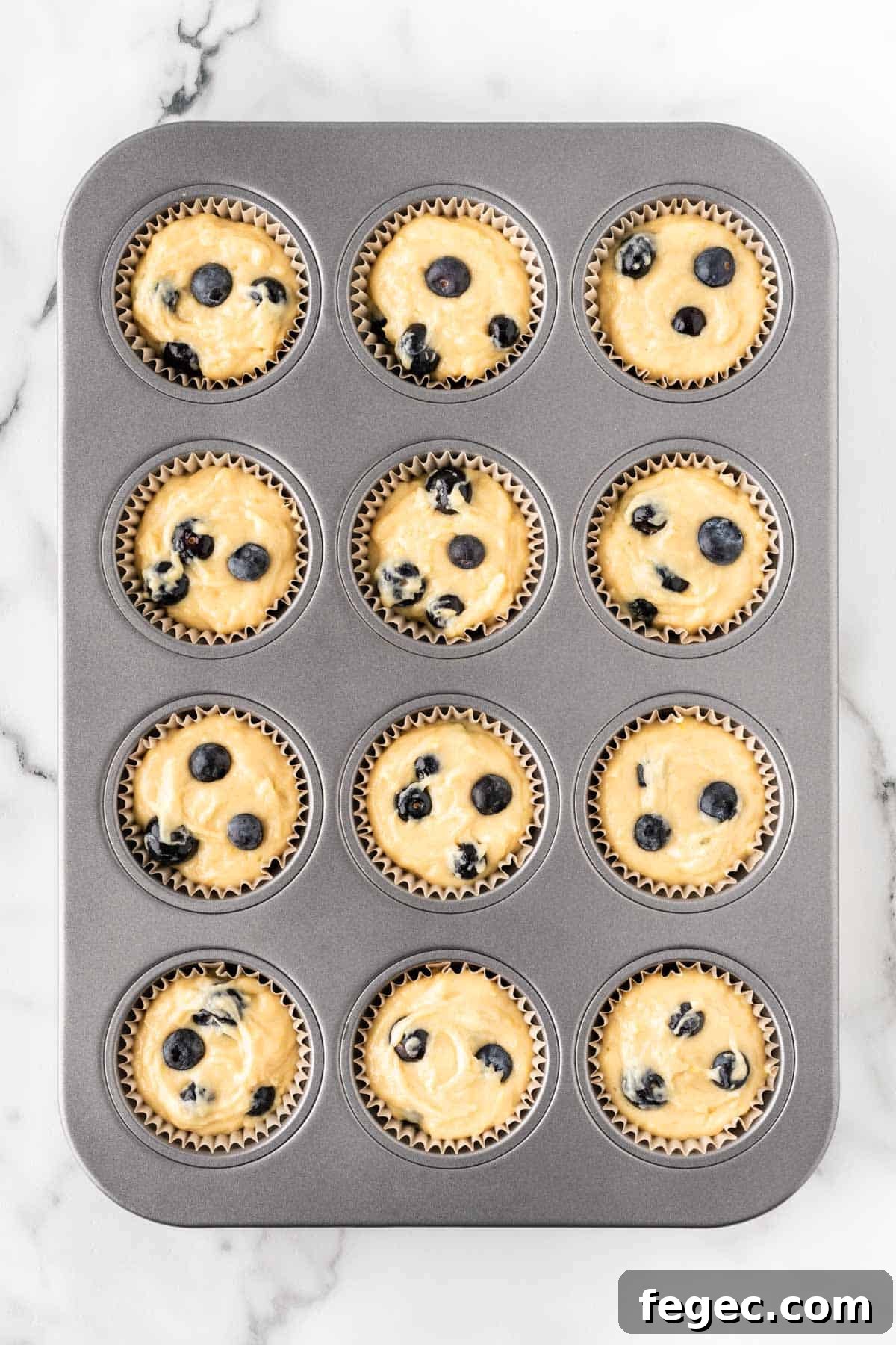 filling muffin tins with muffins batter