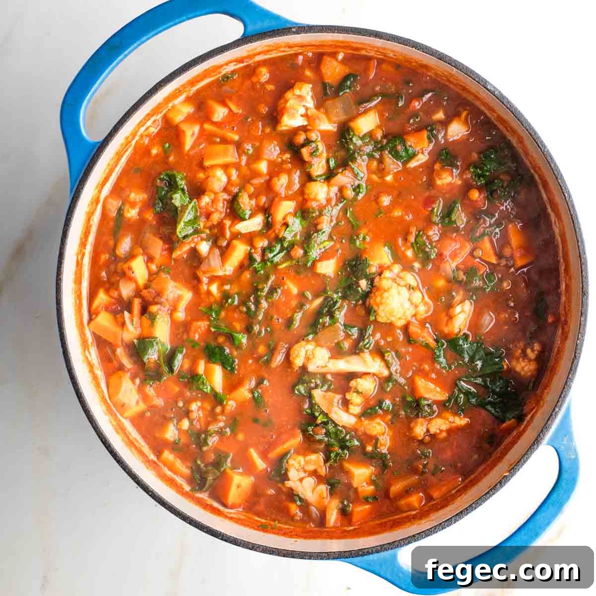 Wilted kale in a pot of chunky veggie stew.