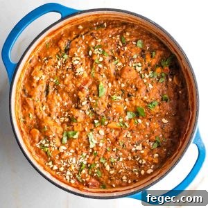 Dutch oven filled with thick and chunky tomato based stew.