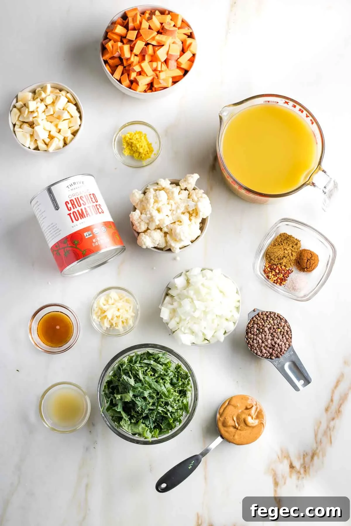 Chopped veggies in bowls, plus other ingredients laid out to make vegan peanut butter stew.
