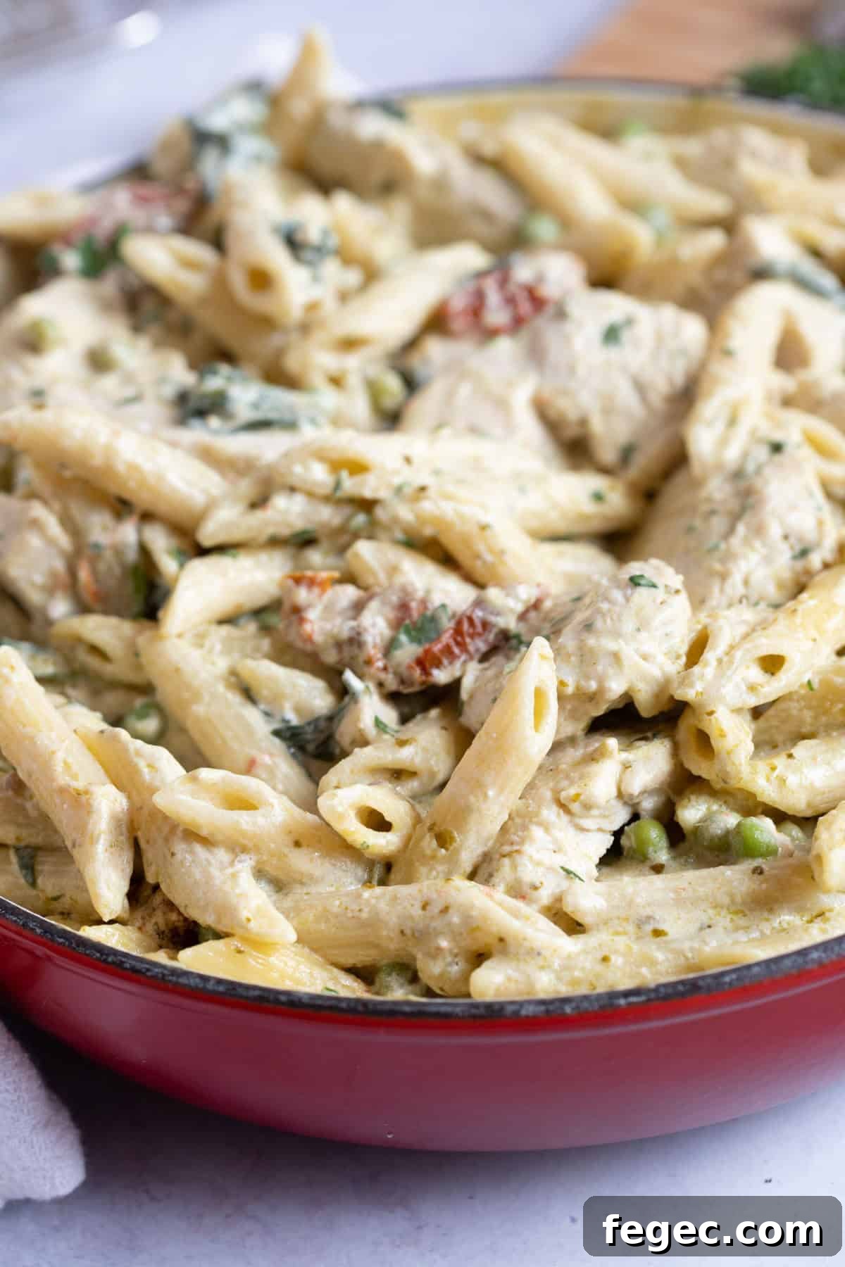 Chicken pesto pasta in a red pan.