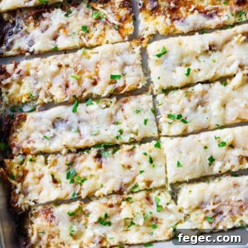 Cheesy Garlic Cauliflower Breadsticks Recipe for Low-Carb Snacking 20 Sliced breadsticks on a cookie sheet.