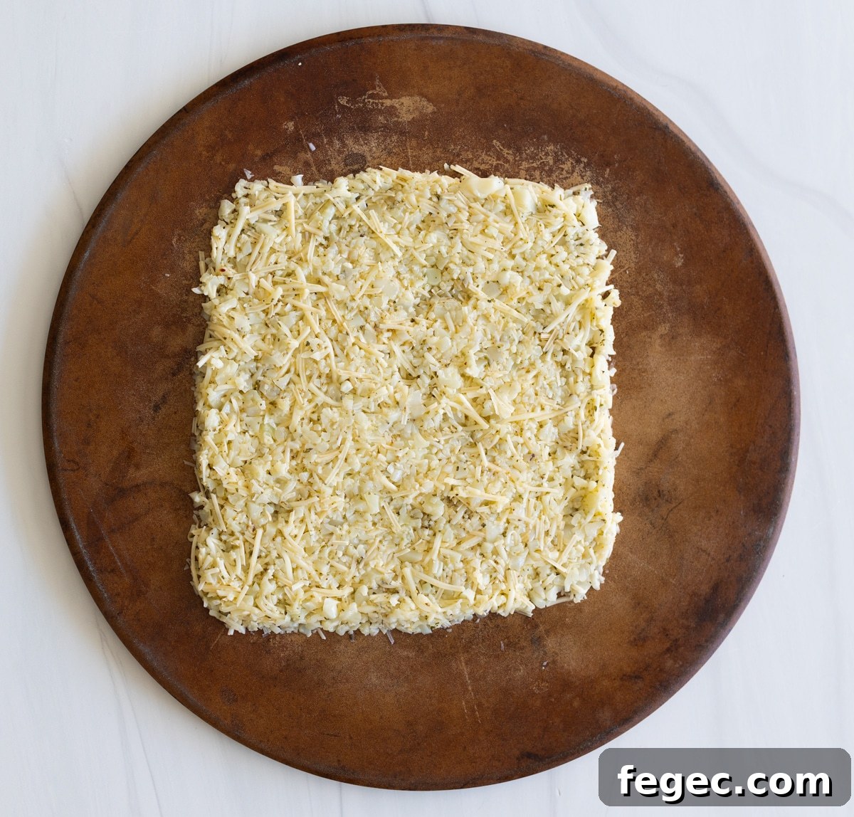 Cheesy Garlic Cauliflower Breadsticks Recipe for Low-Carb Snacking 7 Person shaping cauliflower breadsticks on a baking stone.
