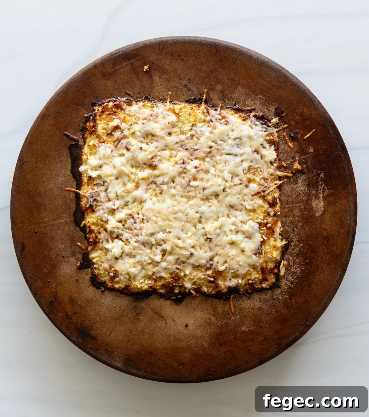 Cheesy Garlic Cauliflower Breadsticks Recipe for Low-Carb Snacking 9 Person topping the cooked cauliflower breadsticks on a pizza stone