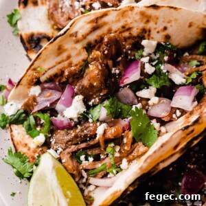 A close-up of a lamb barbacoa taco with toppings.