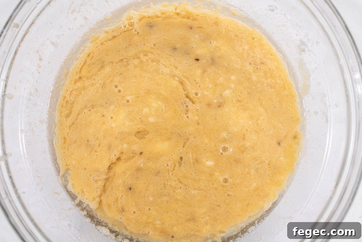 Batter for banana muffins in glass bowl.