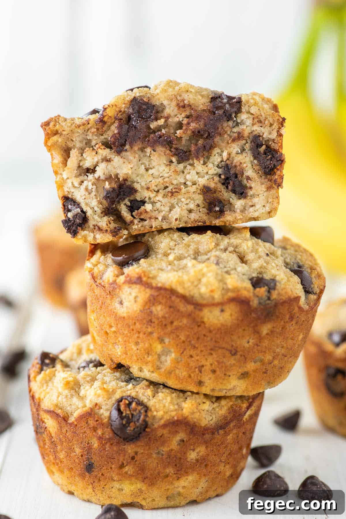 3 stacked almond flour banana muffins with one on top cut in half