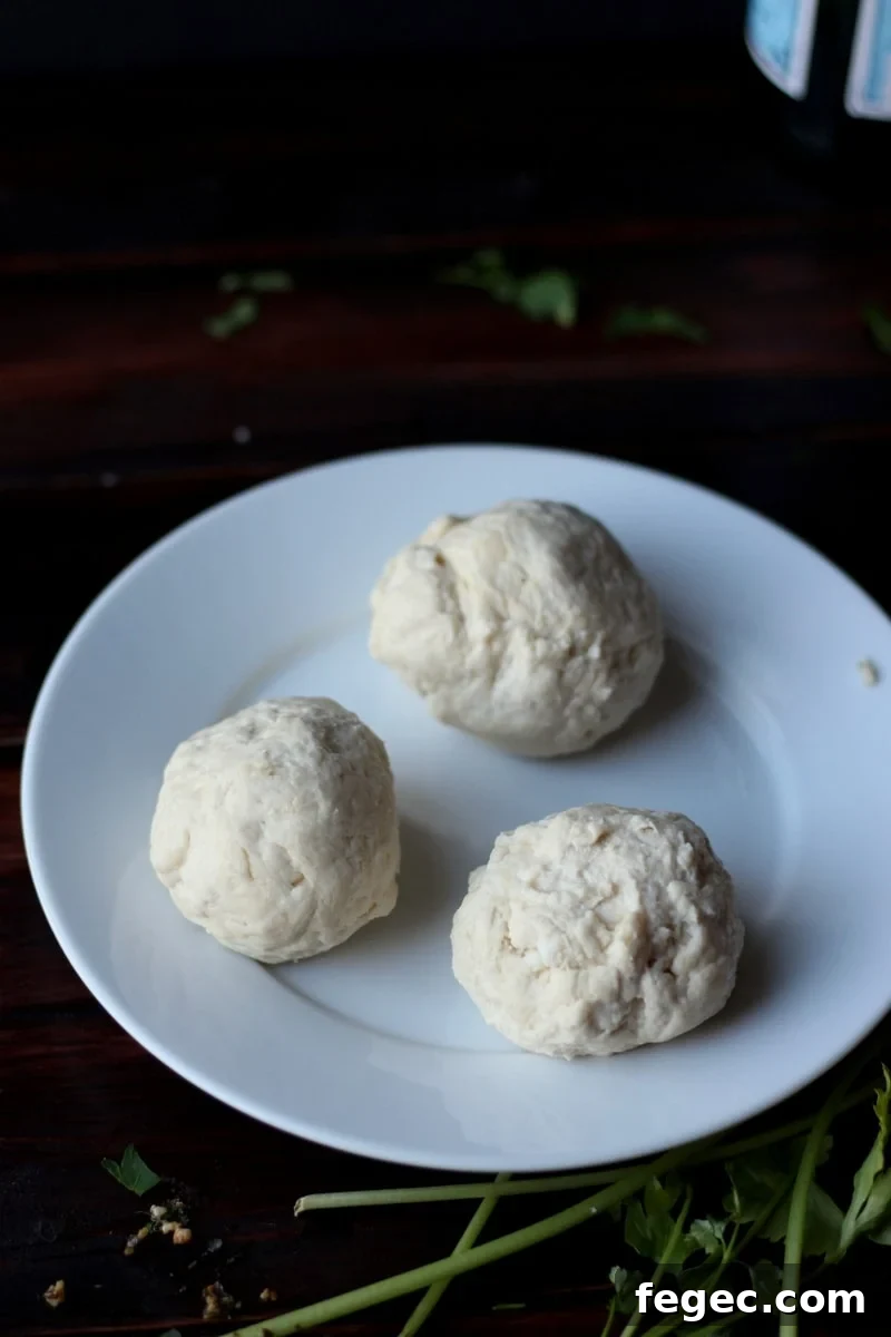 Three cheese stuffed dumplings on a white plate.