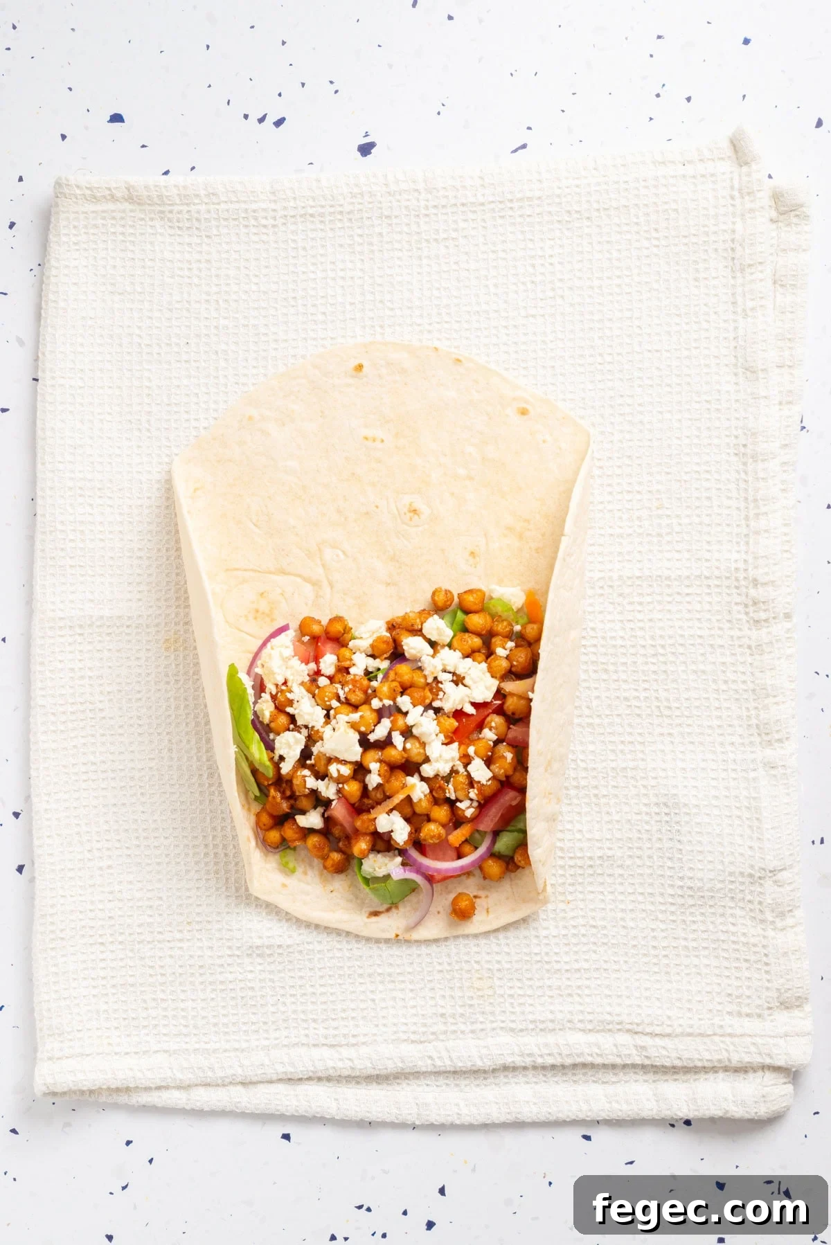 An overhead image of rolling the tortilla wrap.