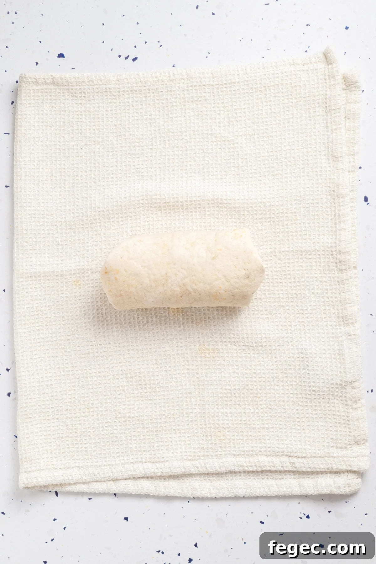 An overhead image of rolling the chickpea wrap.