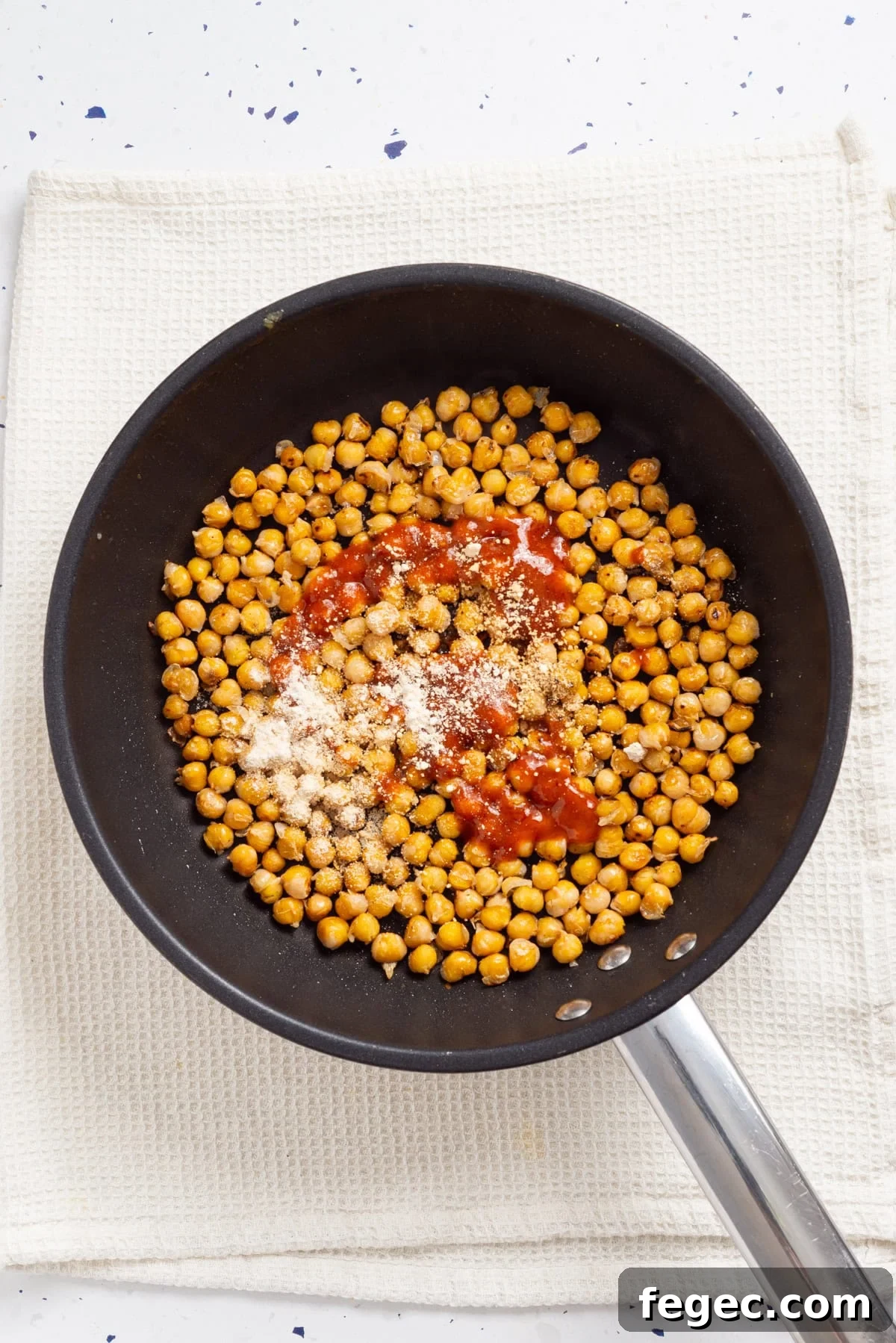 An overhead image of cooking chickpeas in a skillet.