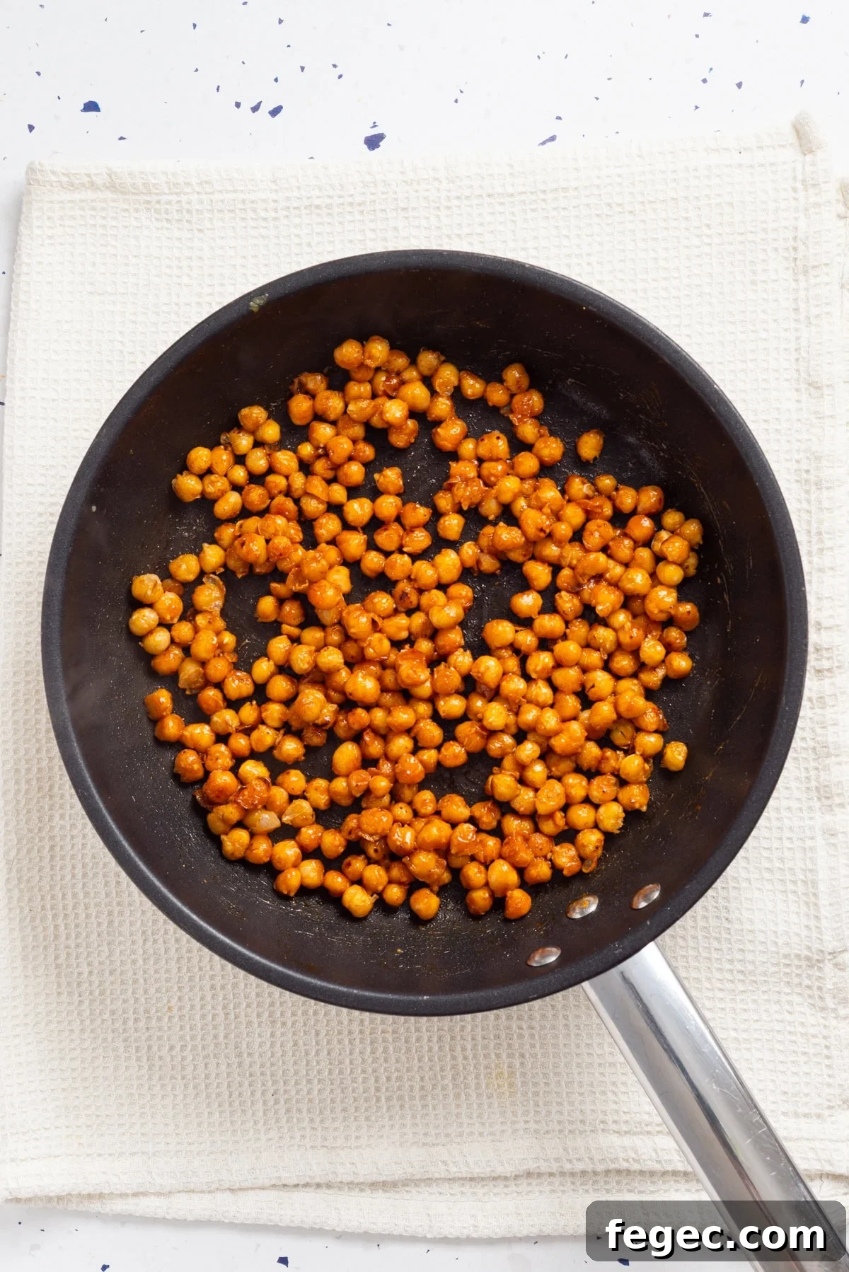 An overhead image of cooked chickpeas in a pan.