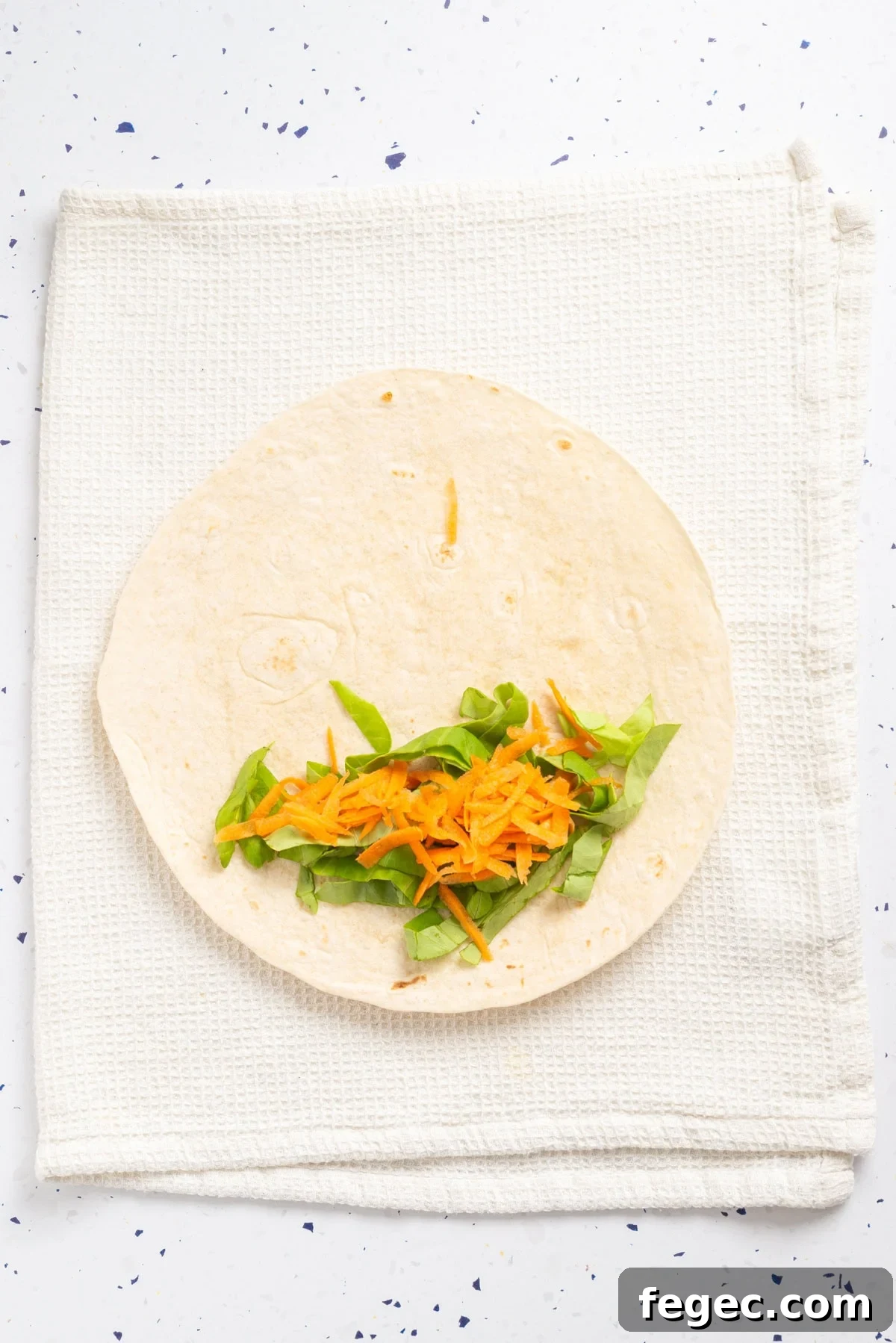 An overhead image of arranging veggies on tortillas.