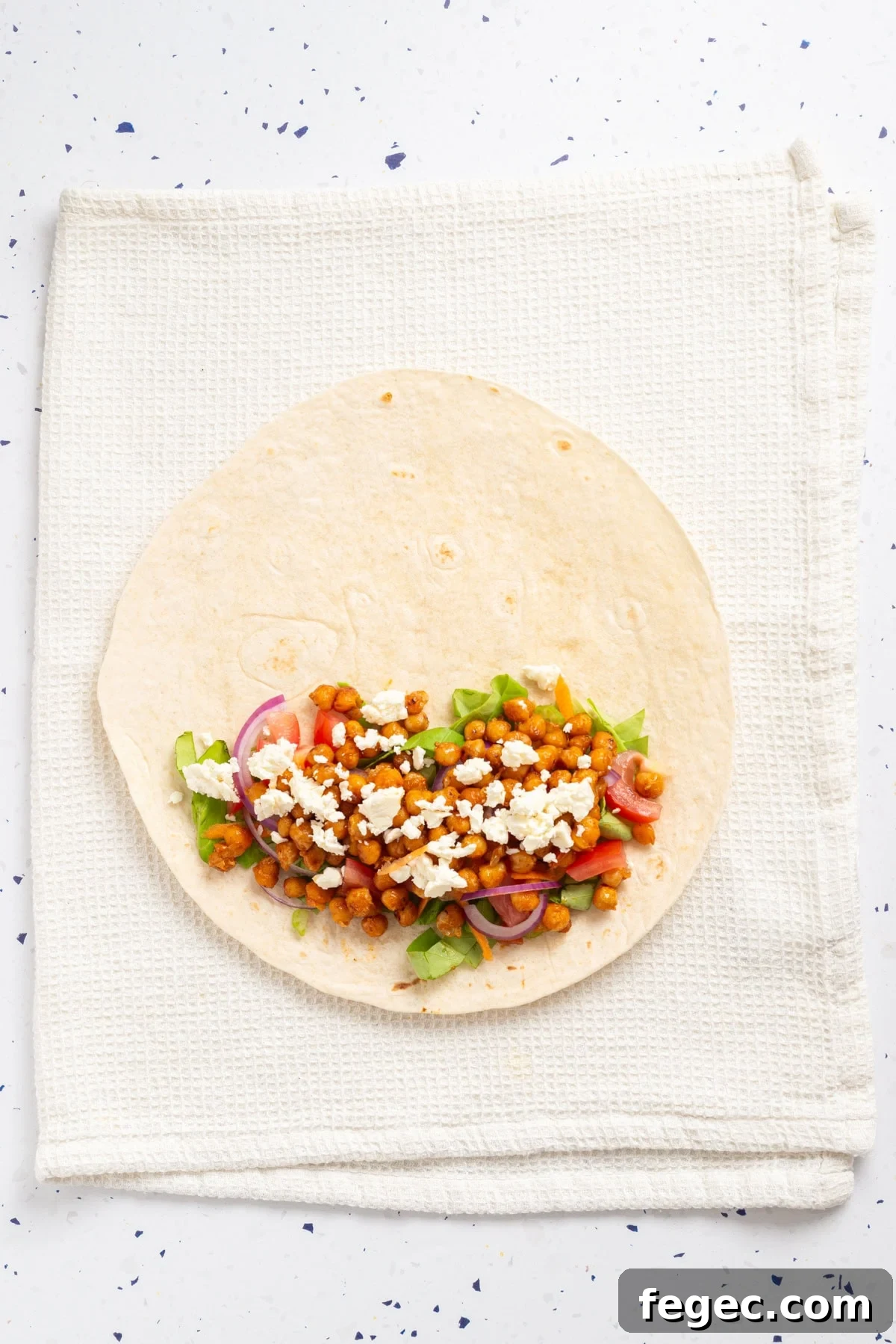 An overhead image of adding feta cheese to the wrap.
