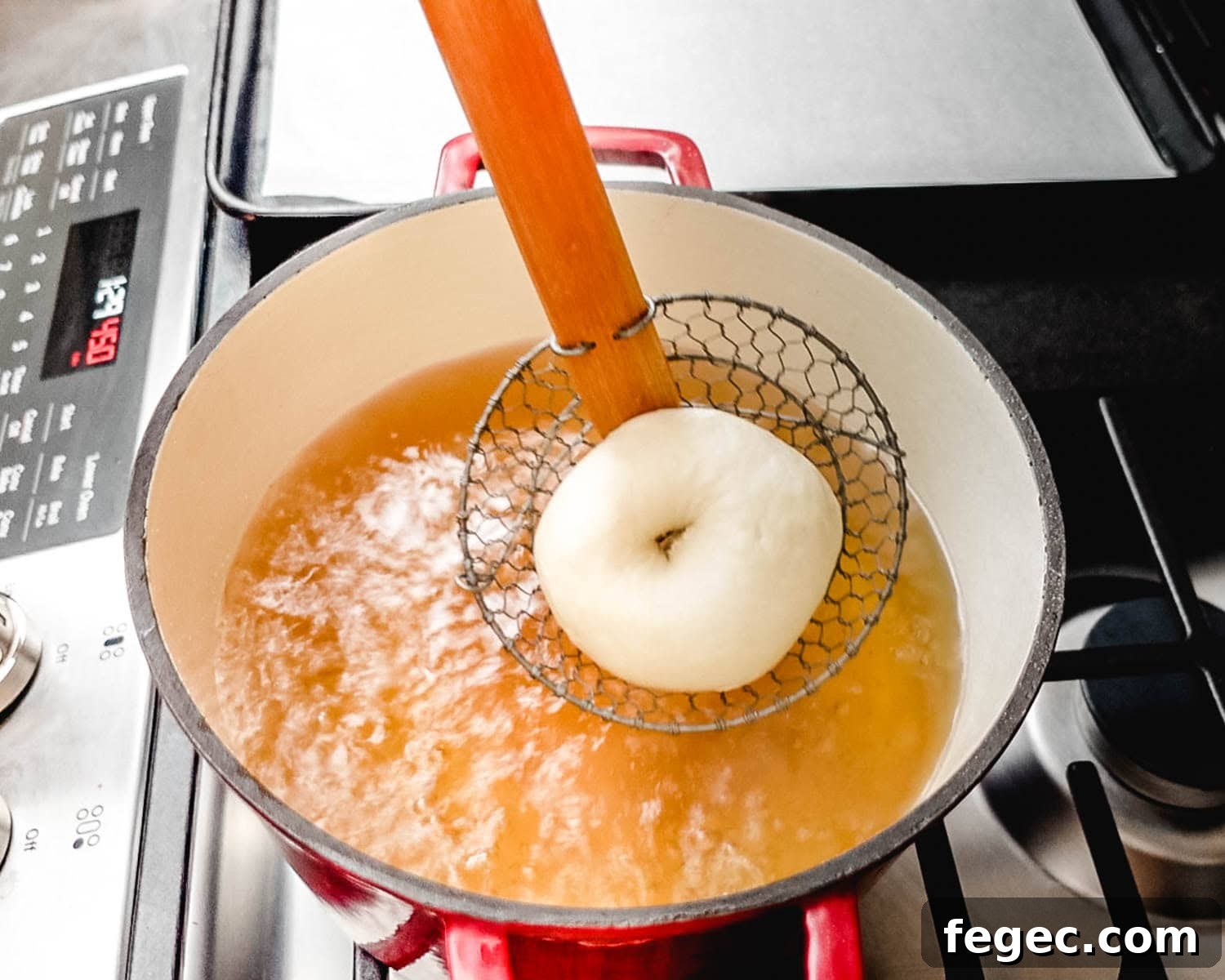 Homemade Onion Bagels: Authentic Recipe Ready in 3 Hours 5 Use a spider tool to lower bagel dough into water bath.