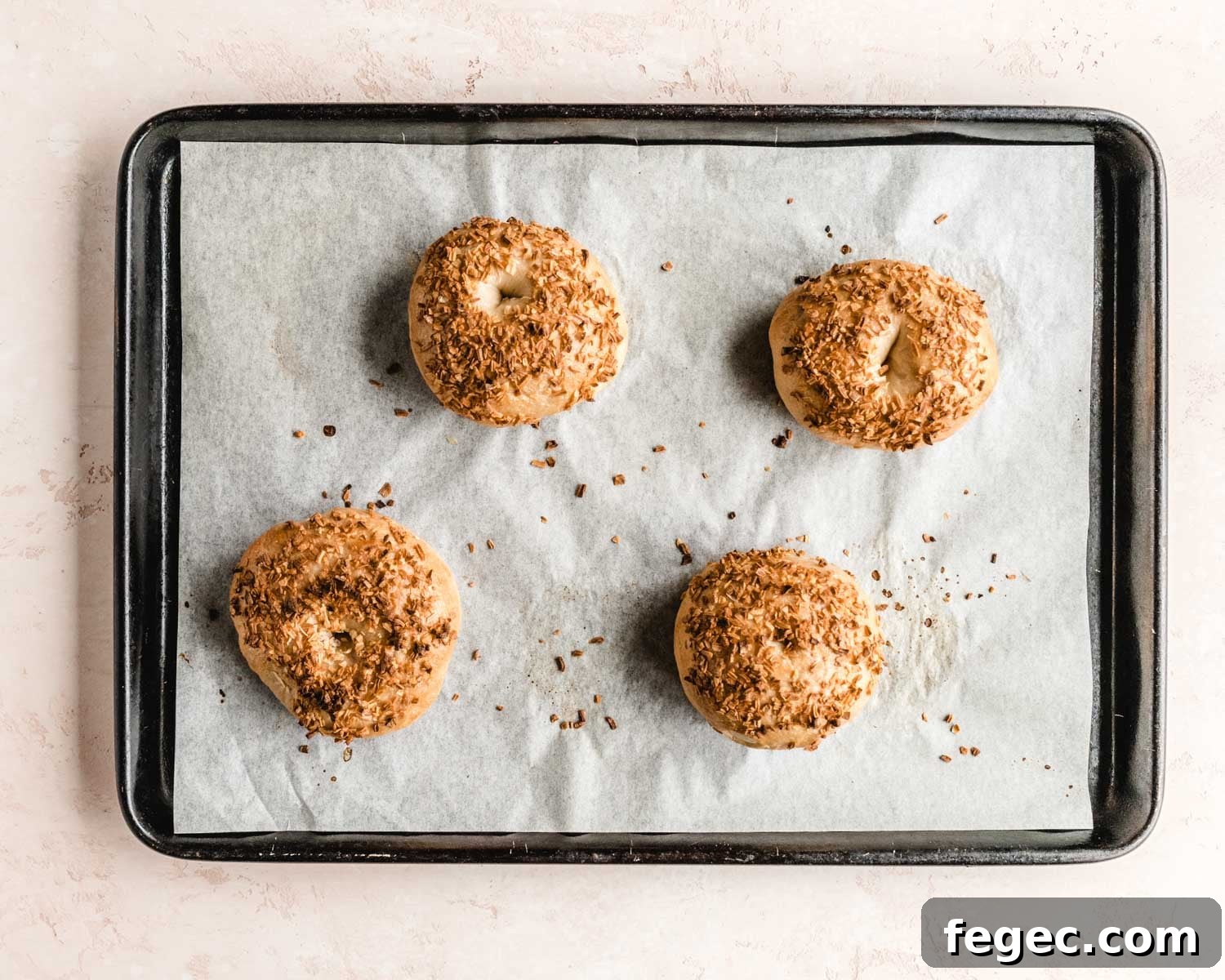 Homemade Onion Bagels: Authentic Recipe Ready in 3 Hours 14 Freshly baked onion bagels on a parchment lined baking sheet.