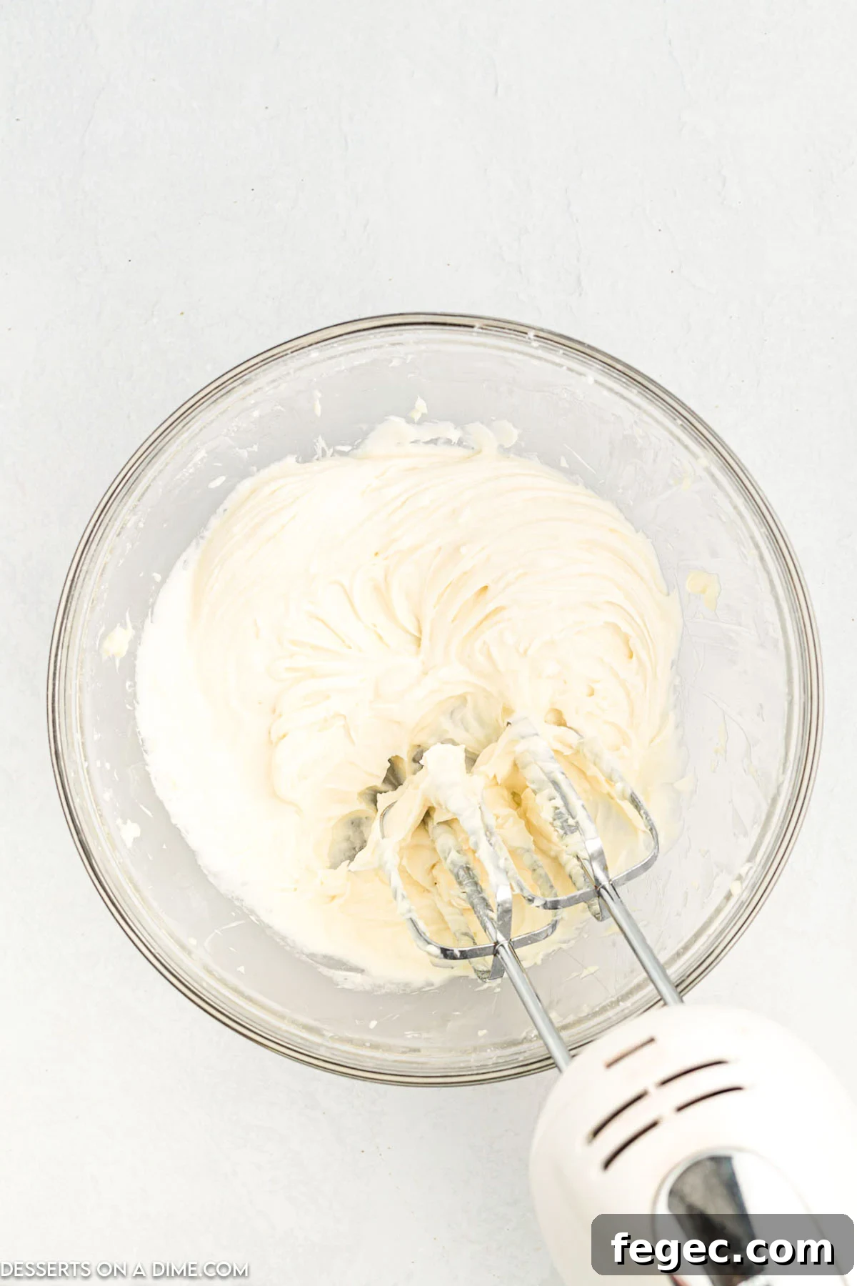 Frosting ingredients in bowl being combined.