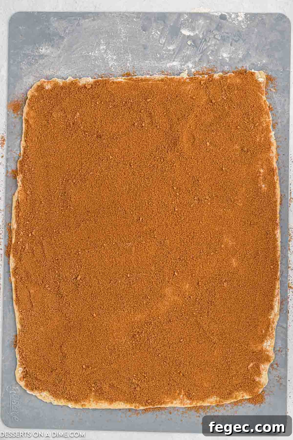 Cinnamon and sugar sprinkled on dough.
