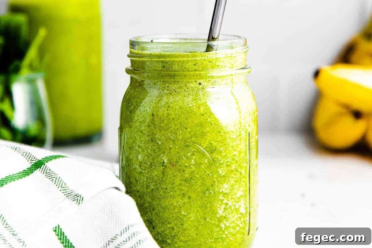 Island Green Tropical Smoothie Recipe for Refreshing Energy 10 Green detox smoothie in a mason jar with metal straw.
