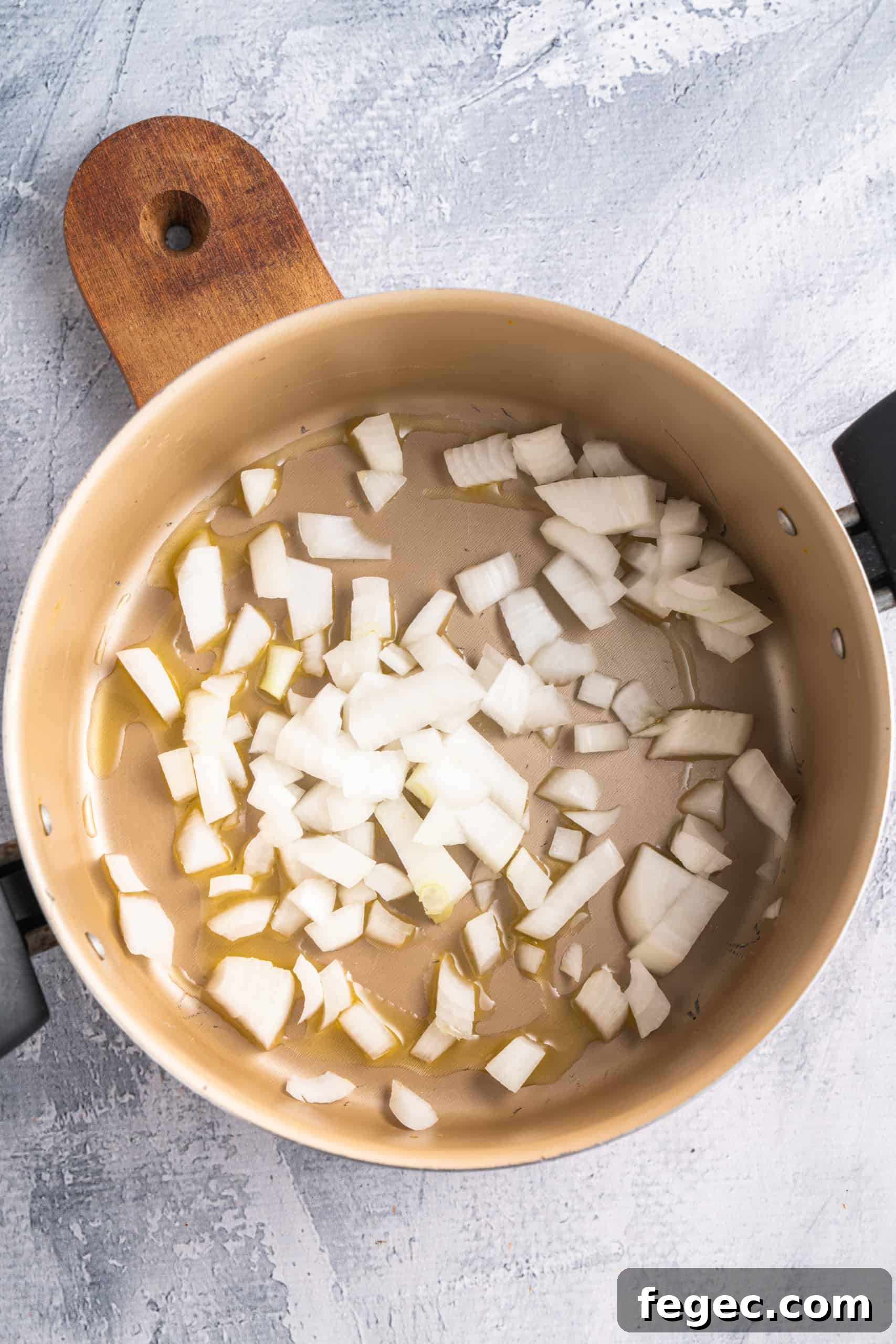 Sautéing diced onions in a saucepan.