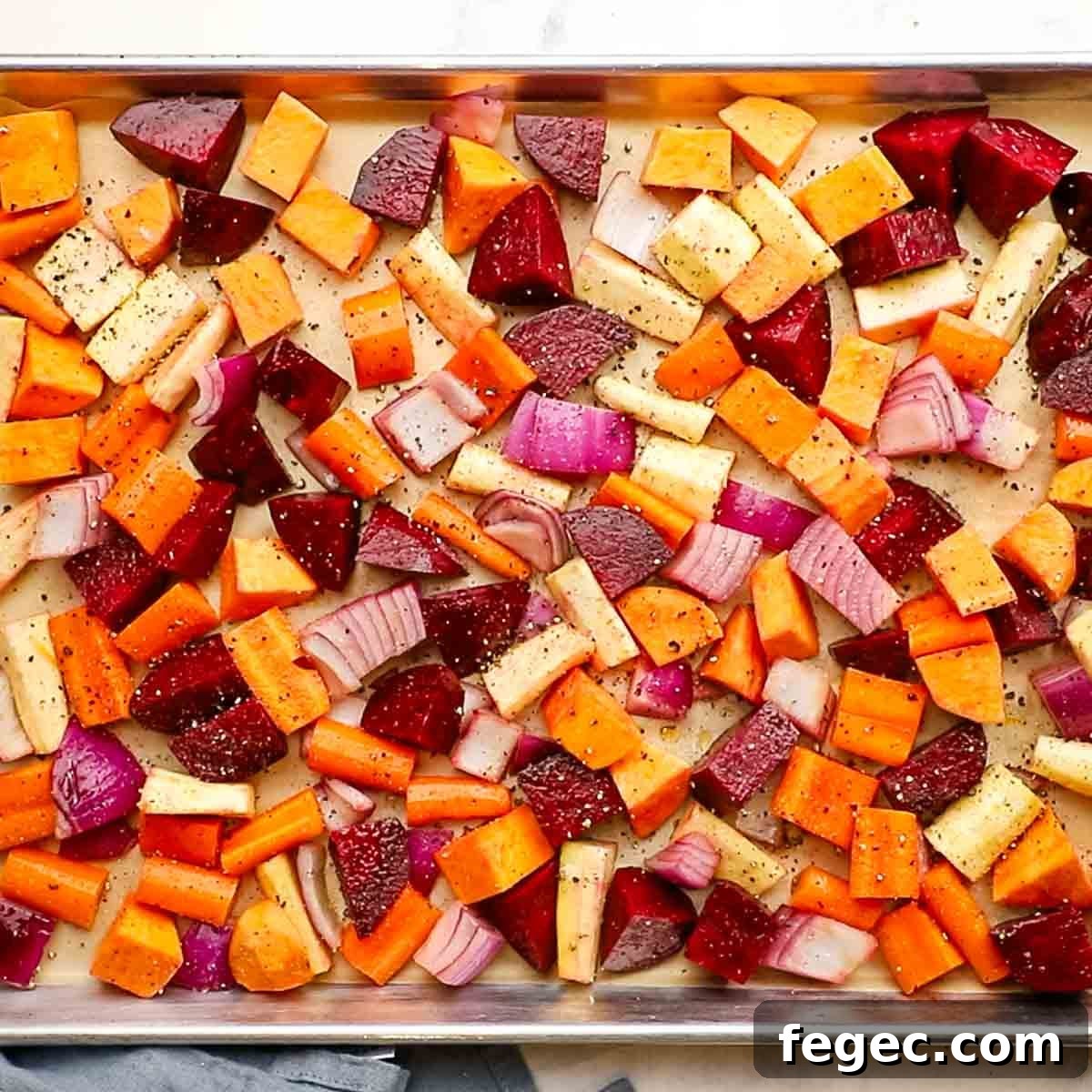 overhead view of a baking sheet with root veggies spread out on it
