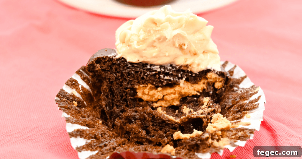 A frosted cupcake sliced in the middle to reveal the dulce de leche cheesecake