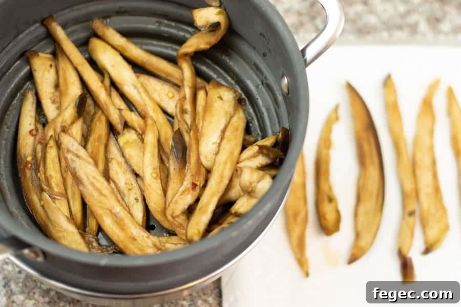 Eggplant jerky in colander and on paper towel