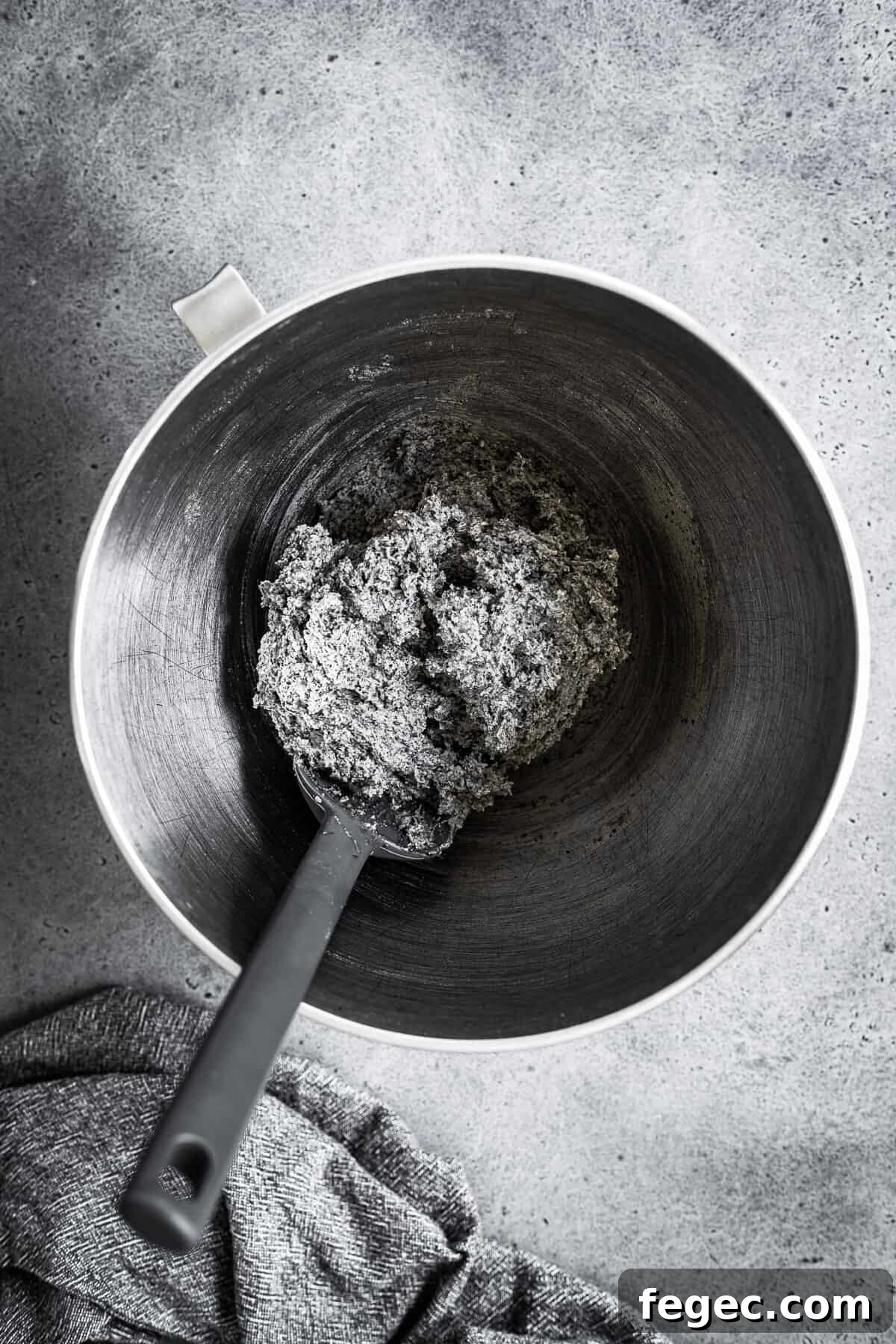 A bowl of cookie dough with dry ingredients added.