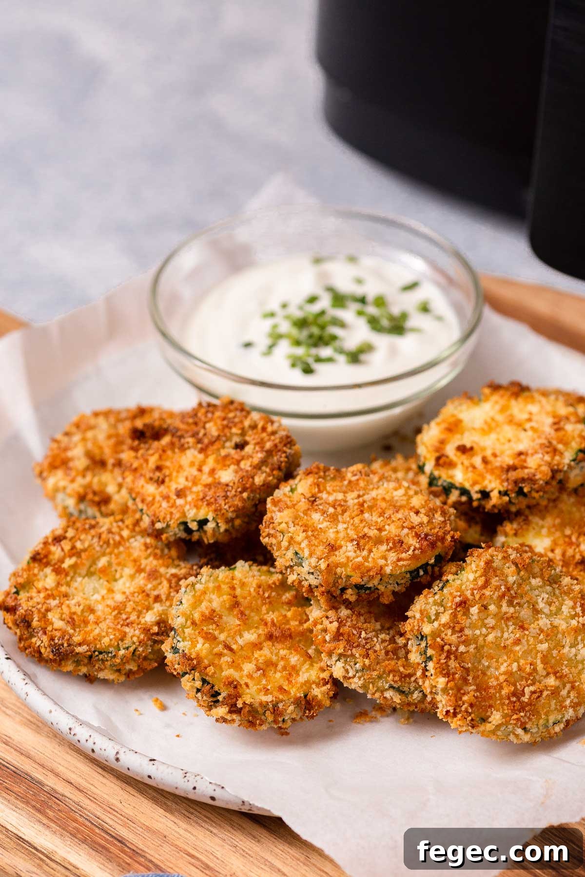 air fryer zucchini chips on a plate with dip