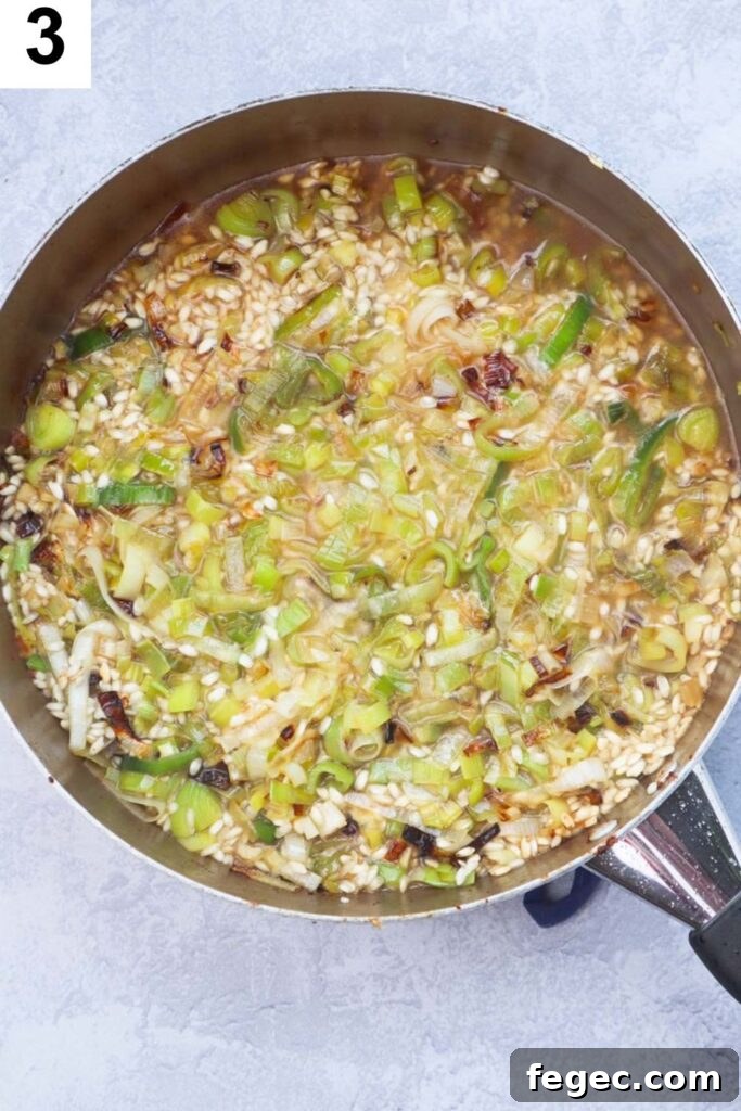 skillet with sauteed leeks, garlic, arborio rice, and broth