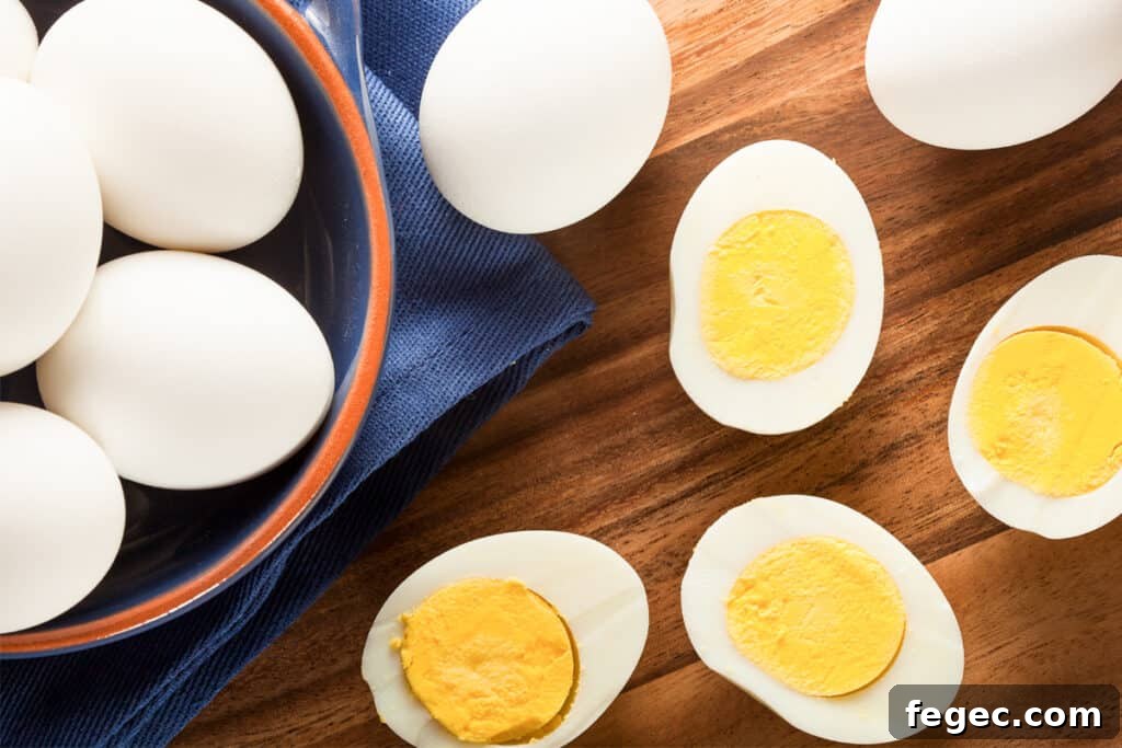 A bowl of hard boiled eggs next to cooked eggs cut in half; boiled eggs baking soda. Boiling eggs baking soda. Boiled egg baking soda.