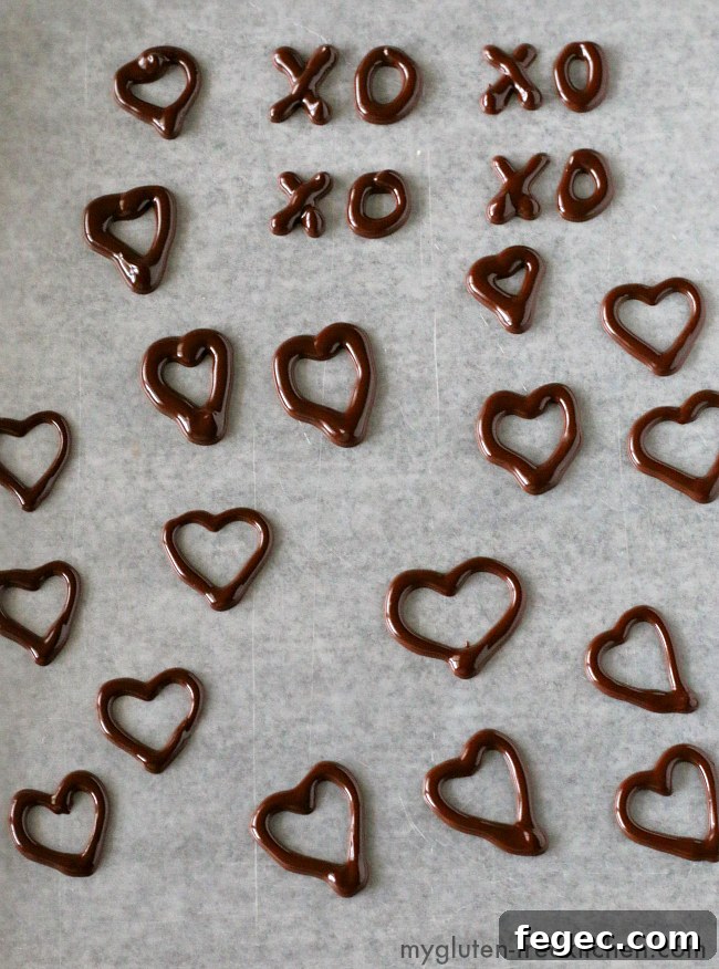 Practicing making Chocolate Heart Decorations. Using melted chocolate with a bit of shortening to make chocolate decorations.