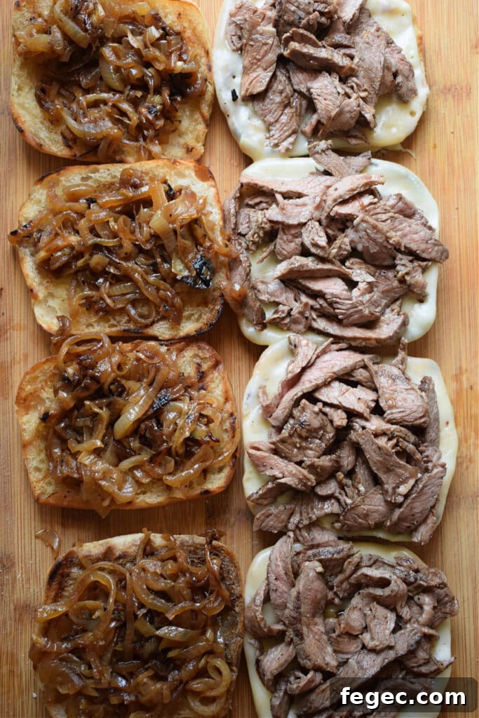 Bread rolls topped with caramelized onions and shaved steak.