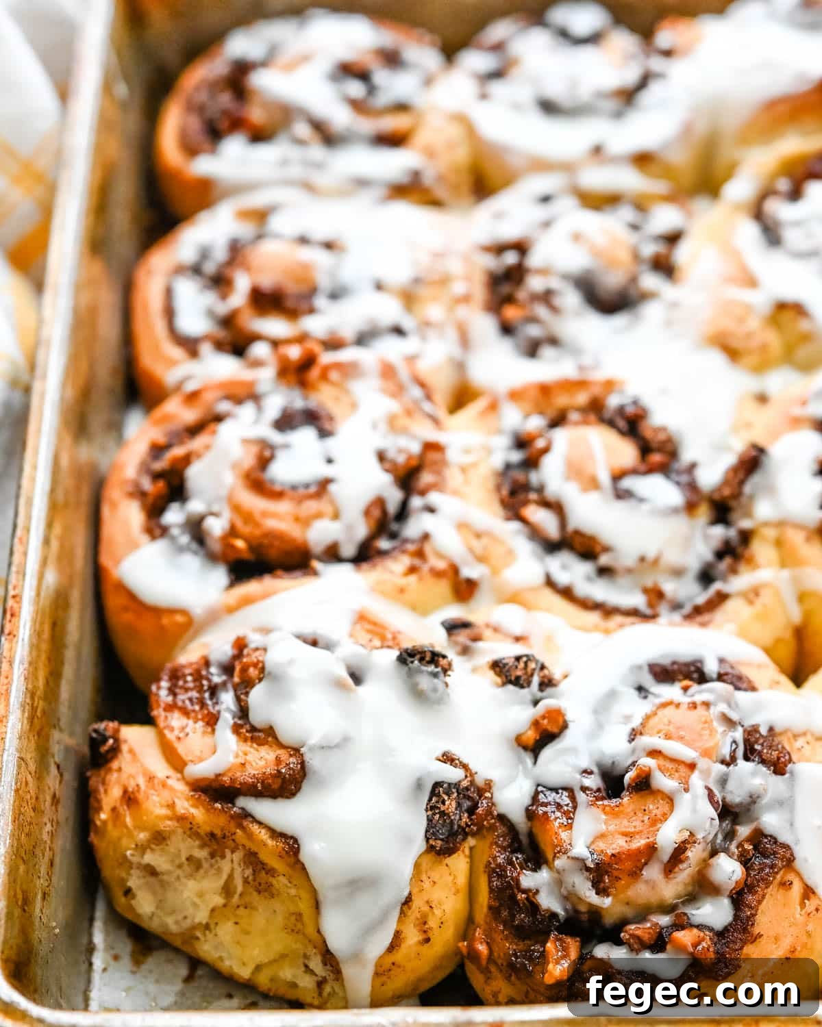 Icing oozing over the gooey cinnamon rolls.