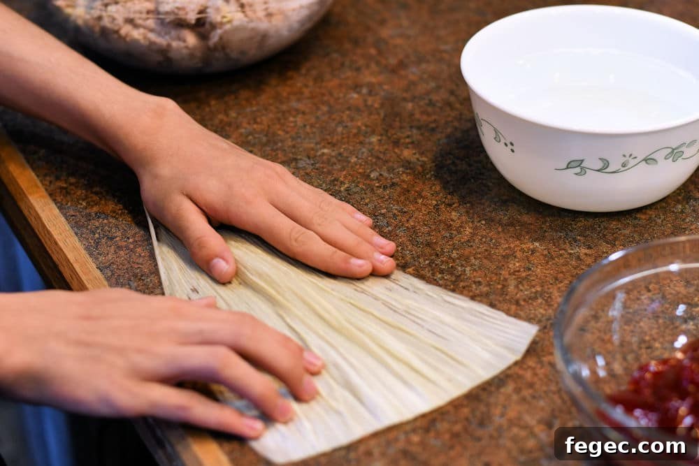 Raspberry Sweet Tamales Recipe — Decadent Dessert Tamales 4 24Bite: spreading corn husk to begin making raspberry tamal