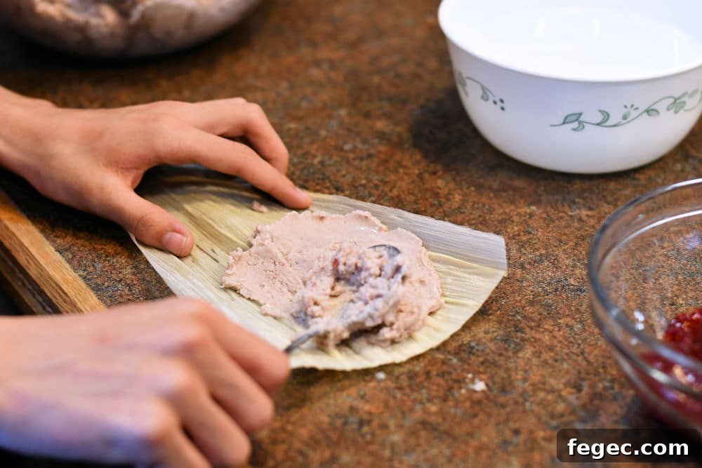Raspberry Sweet Tamales Recipe — Decadent Dessert Tamales 5 24Bite: spreading raspberry sweet masa dough on corn husk