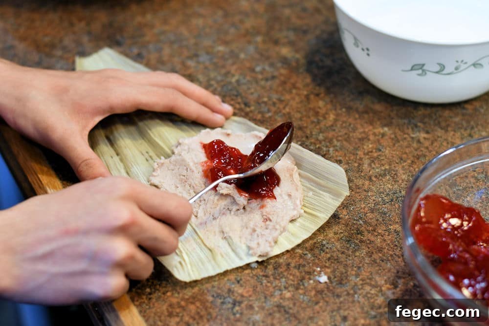 Raspberry Sweet Tamales Recipe — Decadent Dessert Tamales 6 24Bite: spreading raspberry filling on top of masa dough for sweet dessert tamal