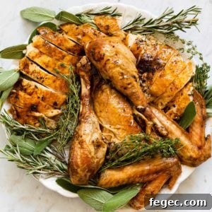 roasted turkey cut up on a platter with fresh herbs