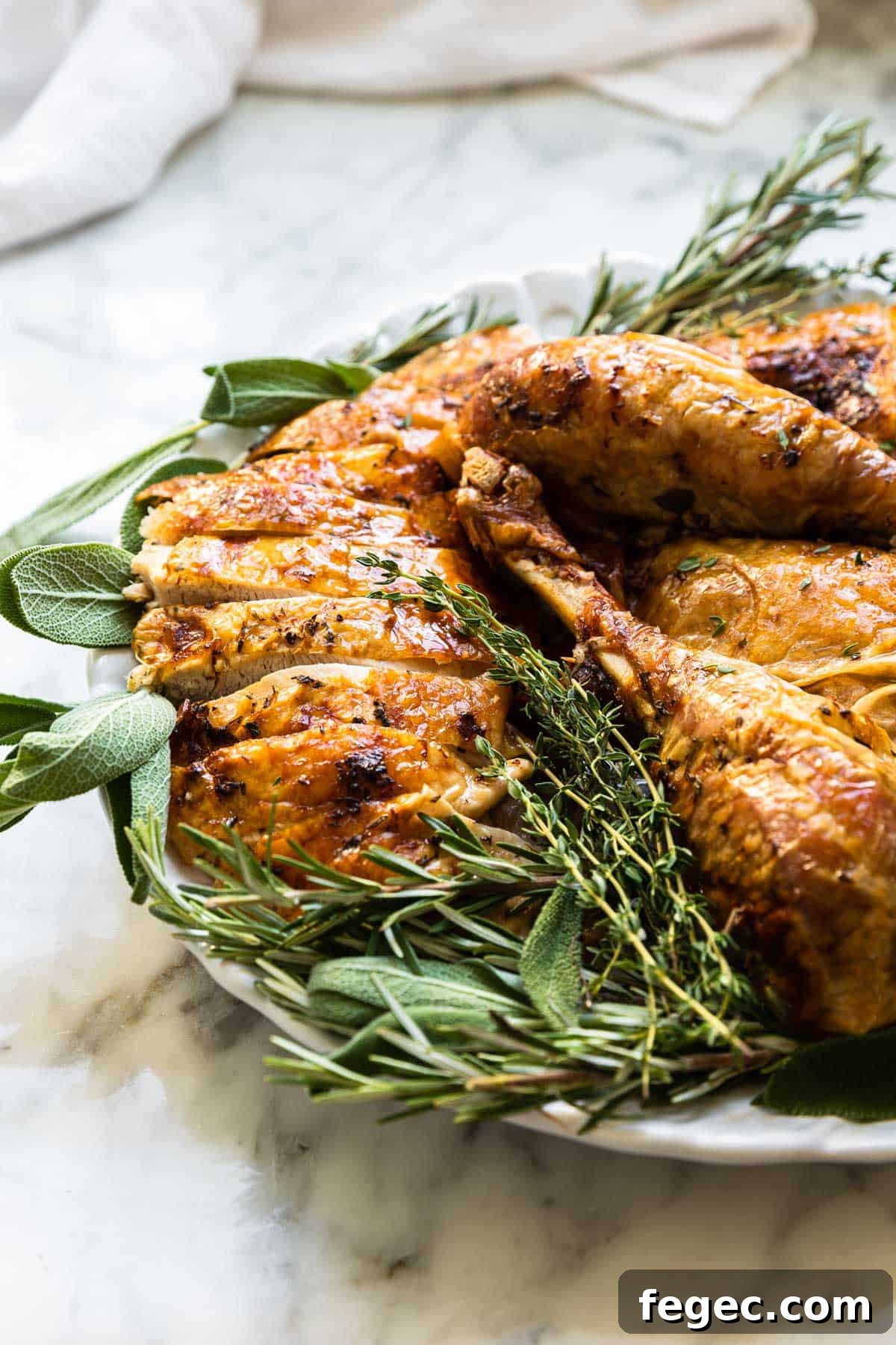 cut up pieces of sliced turkey surrounded by fresh herbs