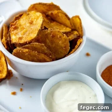 White bowl filled with fried potato slices plus a small bowl of ranch dressing on the side.