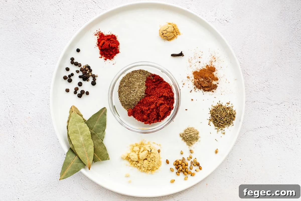 Ingredients for a homemade Old Bay seasoning substitute are arranged on a white plate and placed on a concrete surface.