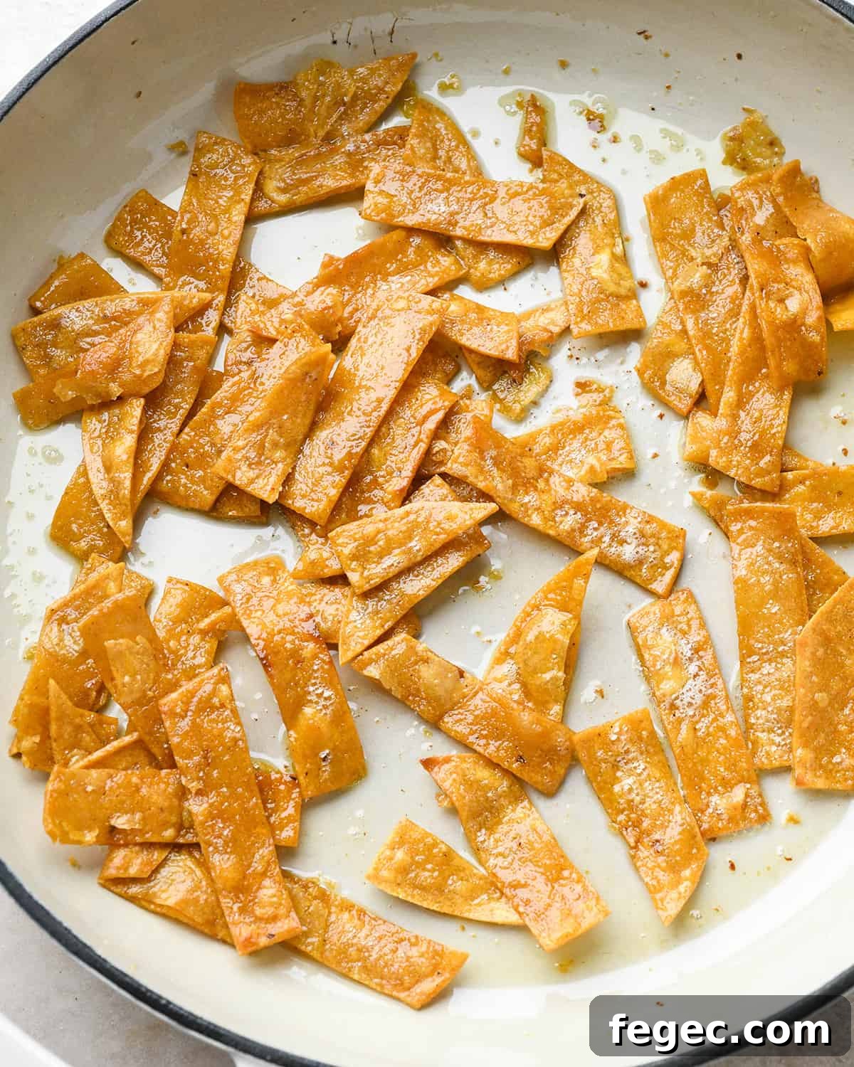 tortilla strips after being cooked in a frying pan
